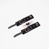 Черные кожаные наручники с золотистой фурнитурой